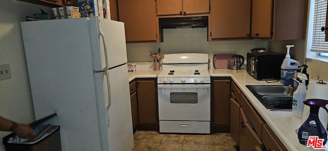 kitchen with sink, white appliances, and ventilation hood