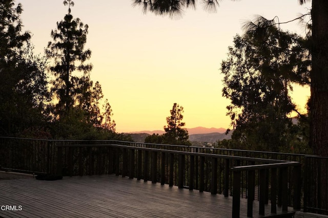 deck at dusk featuring a mountain view