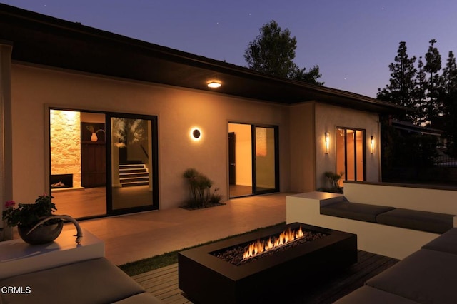 back house at dusk with a patio and a fire pit