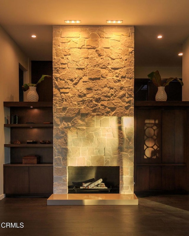 unfurnished living room featuring a fireplace and dark hardwood / wood-style floors