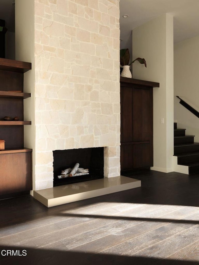 unfurnished living room with dark wood-type flooring and a fireplace