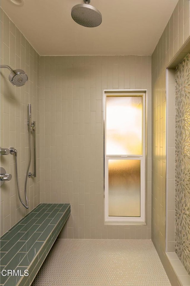 bathroom with a tile shower and tile patterned floors