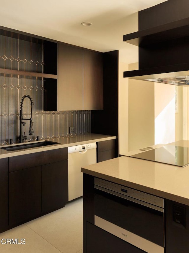 kitchen with sink, light tile patterned floors, dishwasher, oven, and exhaust hood