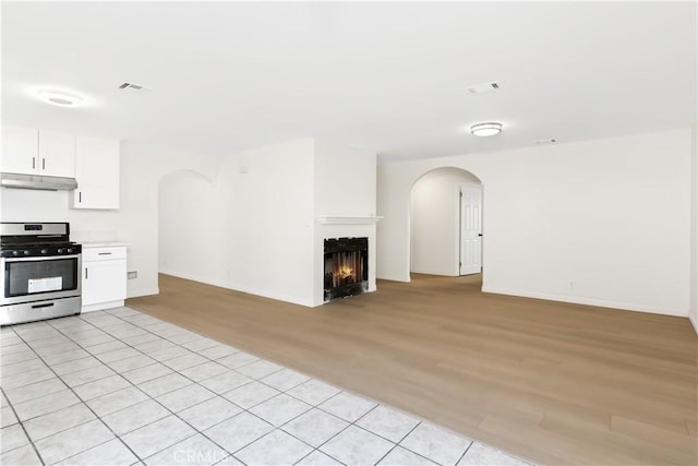 kitchen featuring light hardwood / wood-style floors, white cabinetry, and stainless steel stove