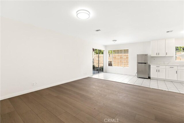 unfurnished living room with light hardwood / wood-style floors and a wealth of natural light