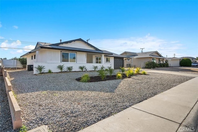 ranch-style house with central AC unit and a garage