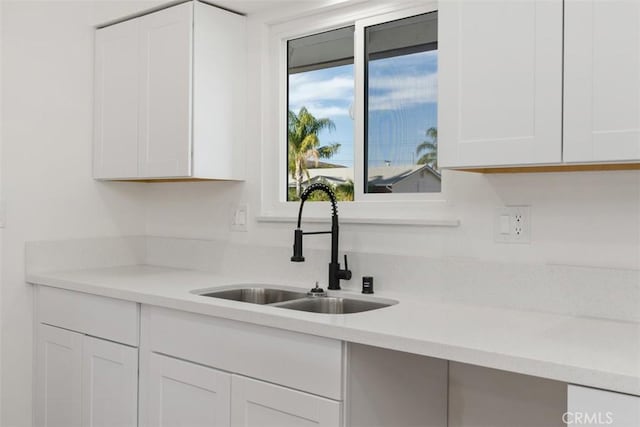 kitchen featuring white cabinetry and sink