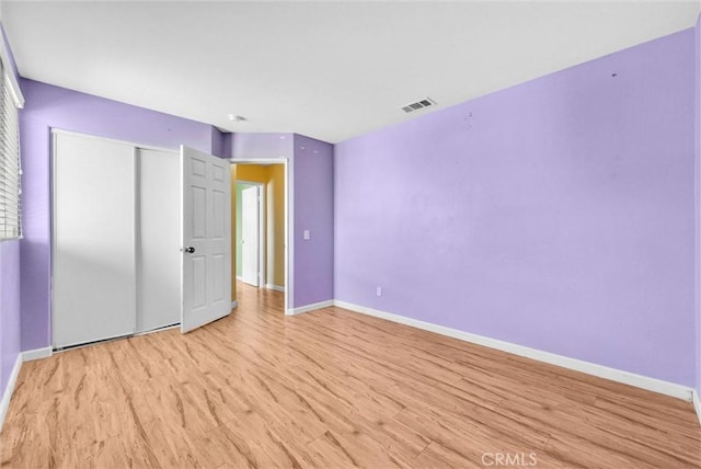 unfurnished bedroom featuring light hardwood / wood-style floors and a closet