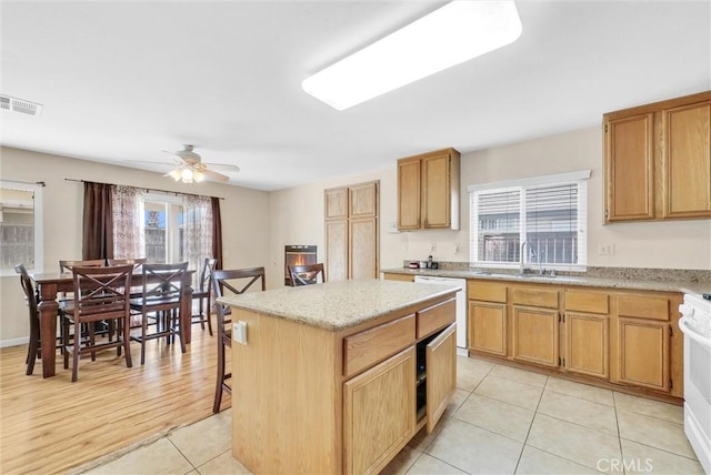 kitchen featuring a wealth of natural light, sink, a kitchen island, and white appliances