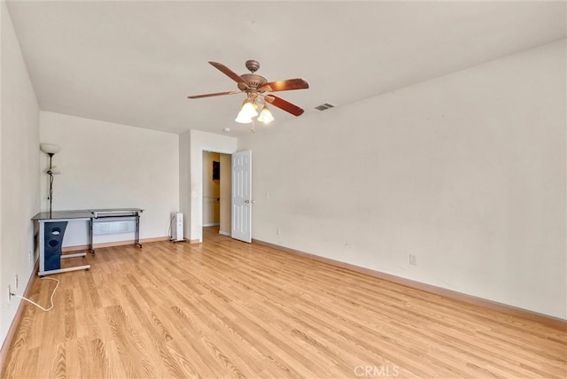 unfurnished room featuring ceiling fan, radiator heating unit, and light wood-type flooring