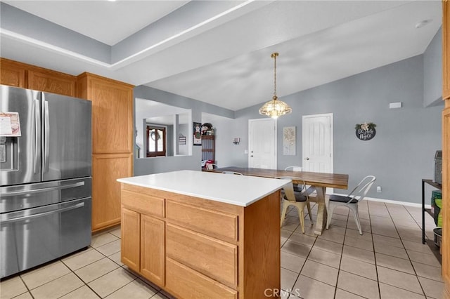 kitchen with a center island, lofted ceiling, light tile patterned floors, decorative light fixtures, and stainless steel fridge with ice dispenser