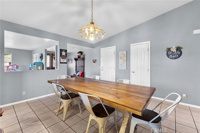 tiled dining space featuring vaulted ceiling and an inviting chandelier