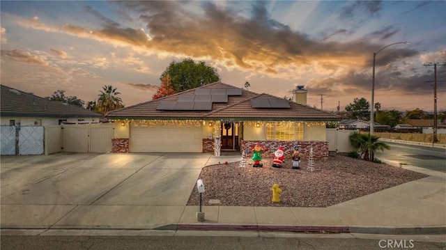 view of front of property with a garage and solar panels