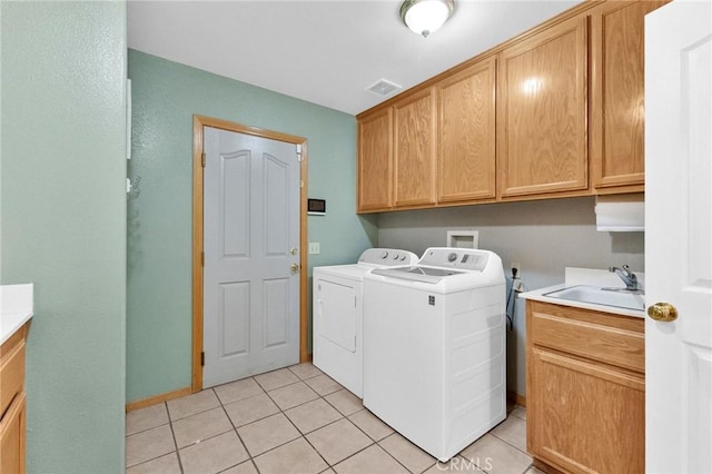 washroom featuring cabinets, light tile patterned floors, sink, and washing machine and clothes dryer