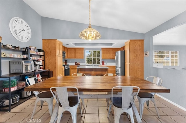 tiled dining room featuring lofted ceiling