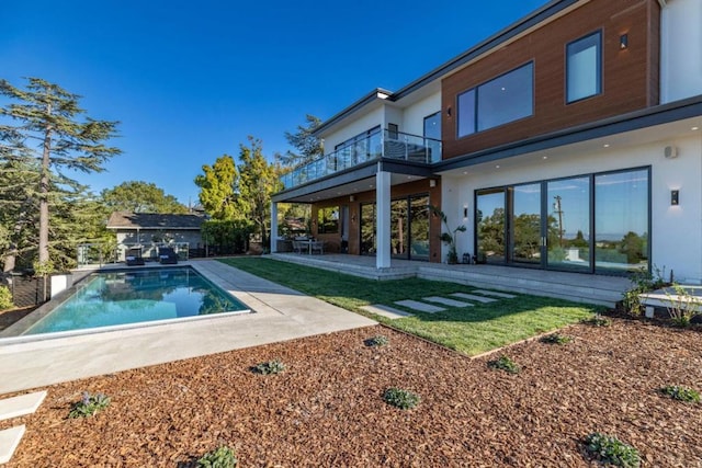 rear view of house featuring a patio area and a balcony