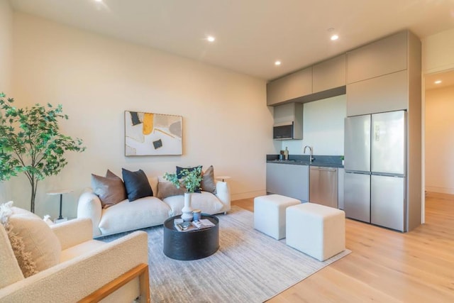 living room featuring sink and light hardwood / wood-style floors