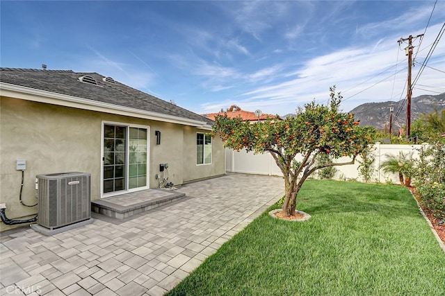 view of yard with a mountain view, a patio area, and central air condition unit