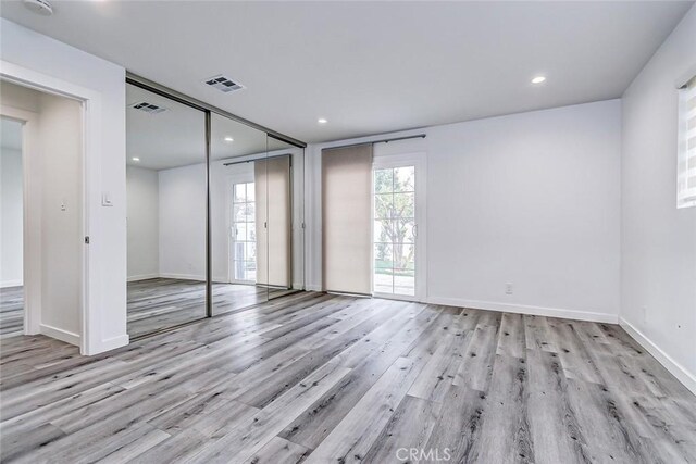 unfurnished room with light wood-type flooring