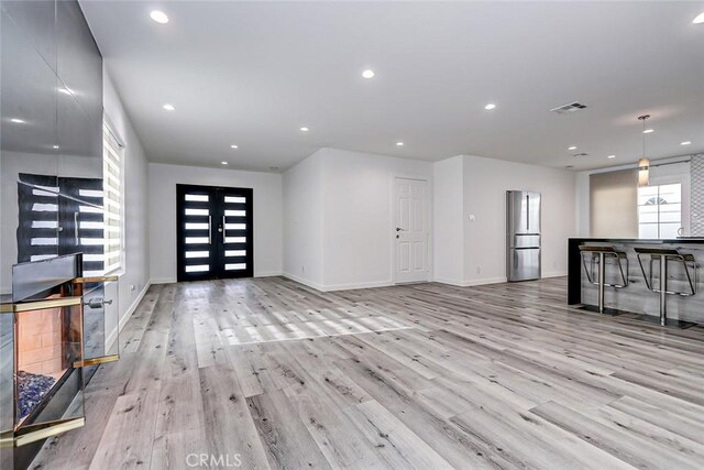 unfurnished living room featuring light hardwood / wood-style flooring and a healthy amount of sunlight