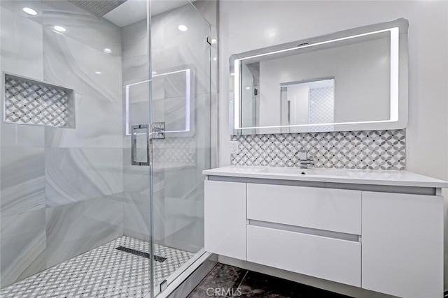 bathroom with tasteful backsplash, vanity, and a shower with shower door