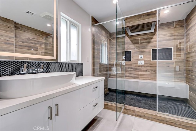 bathroom with vanity, tile patterned floors, tile walls, tasteful backsplash, and an enclosed shower