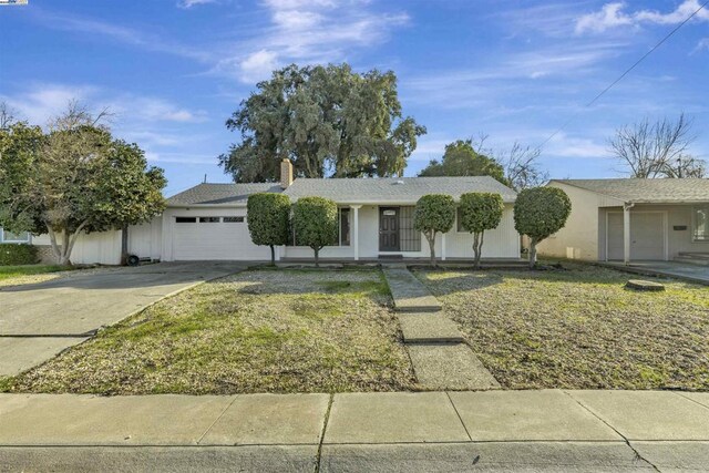 ranch-style house with covered porch, a garage, and a front lawn