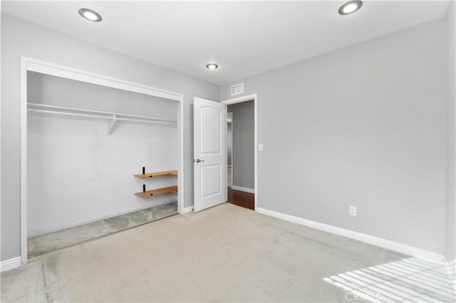 unfurnished bedroom featuring baseboards, visible vents, a closet, and carpet floors
