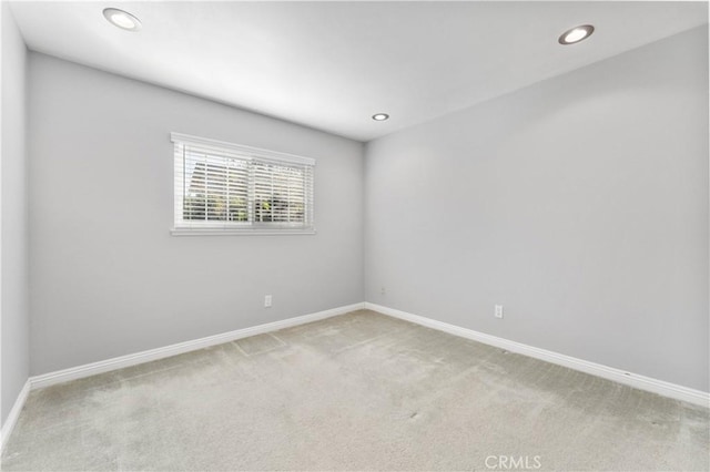 carpeted spare room featuring baseboards and recessed lighting