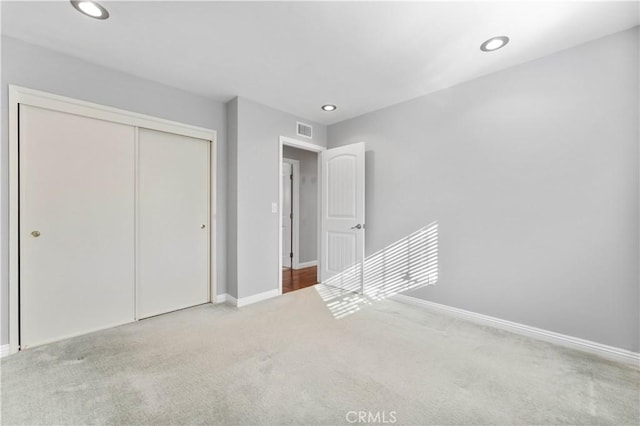 unfurnished bedroom featuring recessed lighting, baseboards, carpet floors, visible vents, and a closet