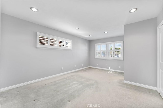 empty room with carpet floors, baseboards, and recessed lighting