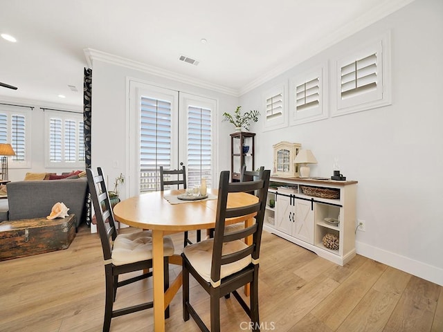 dining area with light hardwood / wood-style floors and ornamental molding