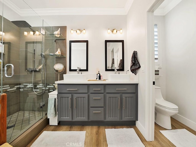 bathroom featuring toilet, ornamental molding, a shower with shower door, and hardwood / wood-style flooring