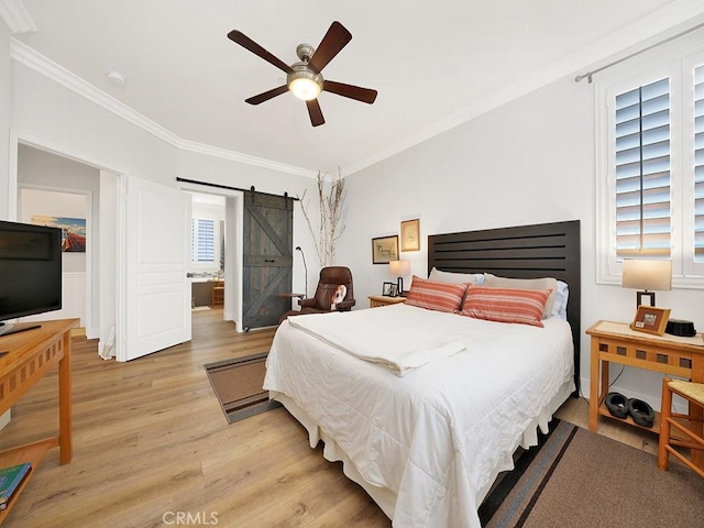 bedroom featuring a barn door, ceiling fan, light hardwood / wood-style floors, and multiple windows