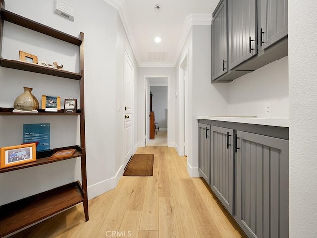 hall featuring ornamental molding and light hardwood / wood-style flooring