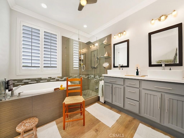 bathroom featuring hardwood / wood-style flooring, separate shower and tub, ceiling fan, and crown molding