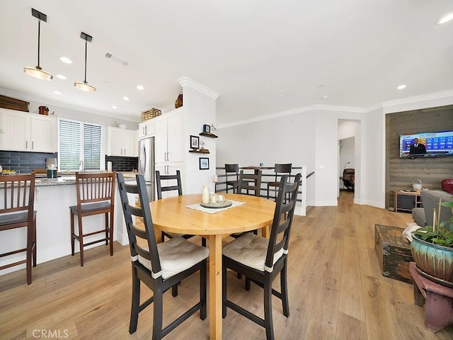 dining room featuring light hardwood / wood-style flooring and ornamental molding