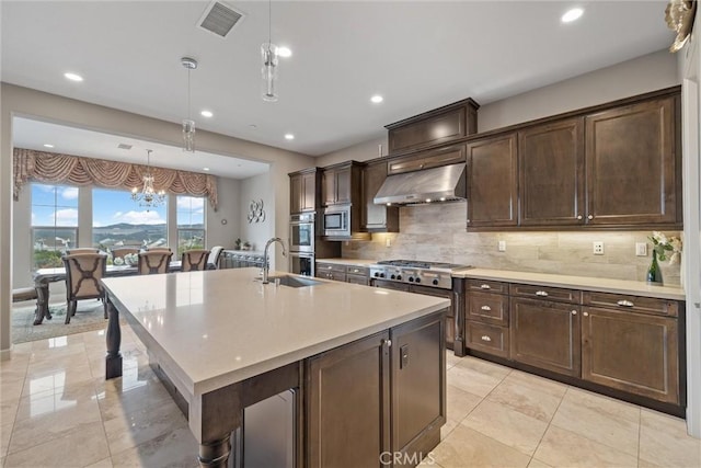 kitchen with dark brown cabinetry, hanging light fixtures, a kitchen breakfast bar, ventilation hood, and a kitchen island with sink