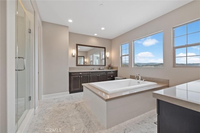 bathroom with vanity and shower with separate bathtub