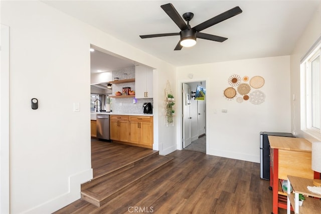 kitchen with dishwasher, sink, ceiling fan, decorative backsplash, and dark hardwood / wood-style flooring