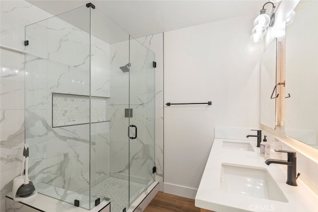 bathroom with wood-type flooring, vanity, and a shower with shower door