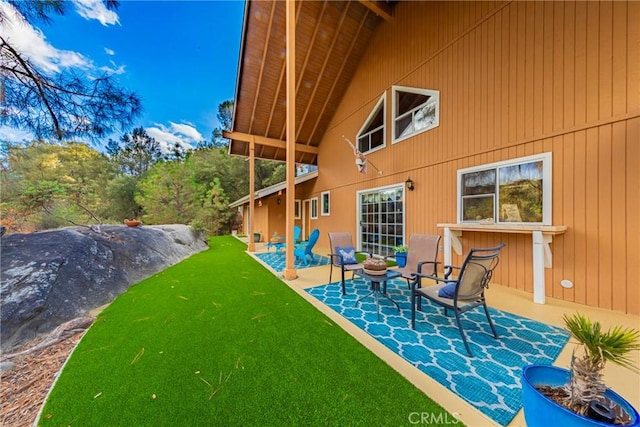 rear view of property with a yard and a patio