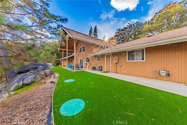 rear view of property featuring a lawn and a patio area