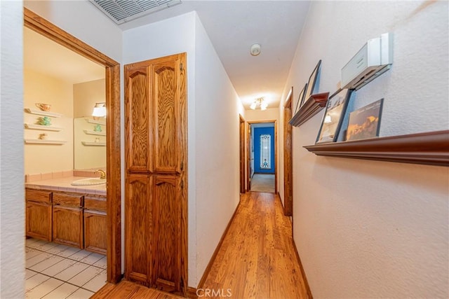 hallway featuring light hardwood / wood-style floors and sink