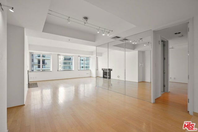 unfurnished room featuring hardwood / wood-style floors and track lighting