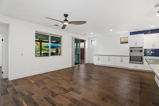 unfurnished living room featuring dark hardwood / wood-style floors and ceiling fan