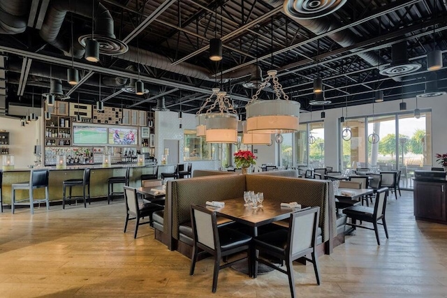 dining area with hardwood / wood-style flooring and bar area