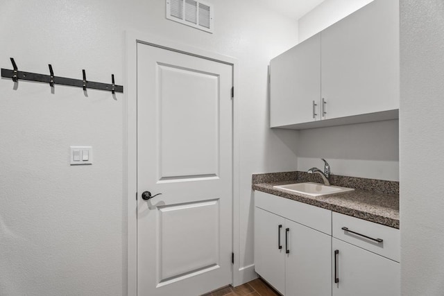 interior space featuring white cabinetry, dark hardwood / wood-style floors, and sink