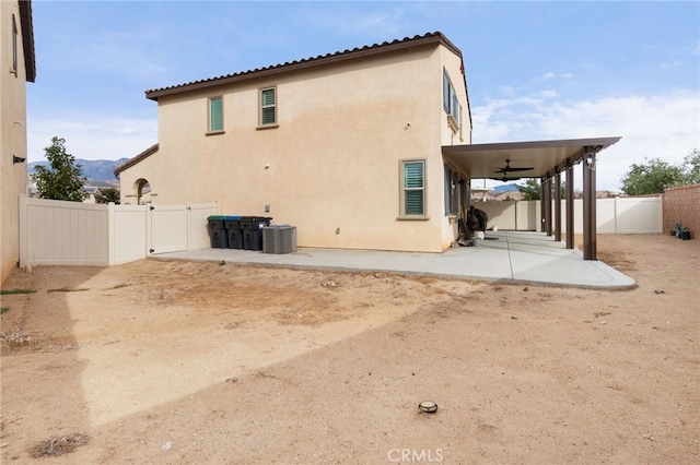 rear view of property featuring central AC, ceiling fan, and a patio area