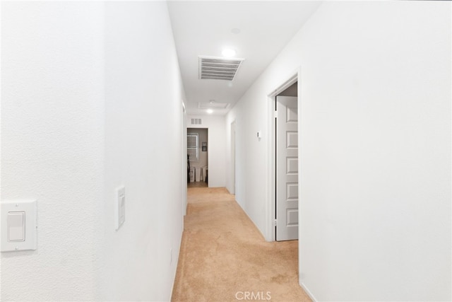 corridor featuring light colored carpet